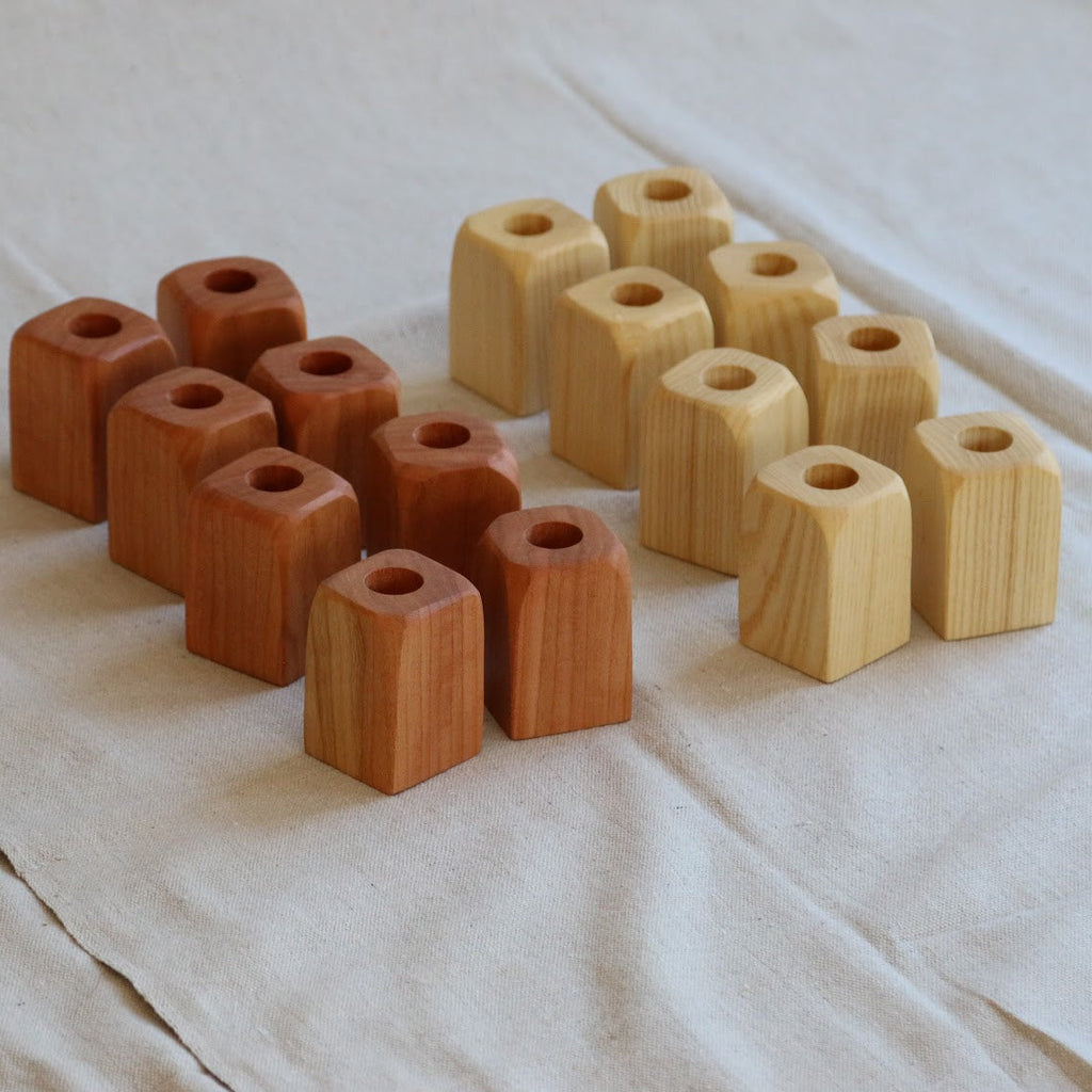 Set of wooden candle holders on a white fabric background