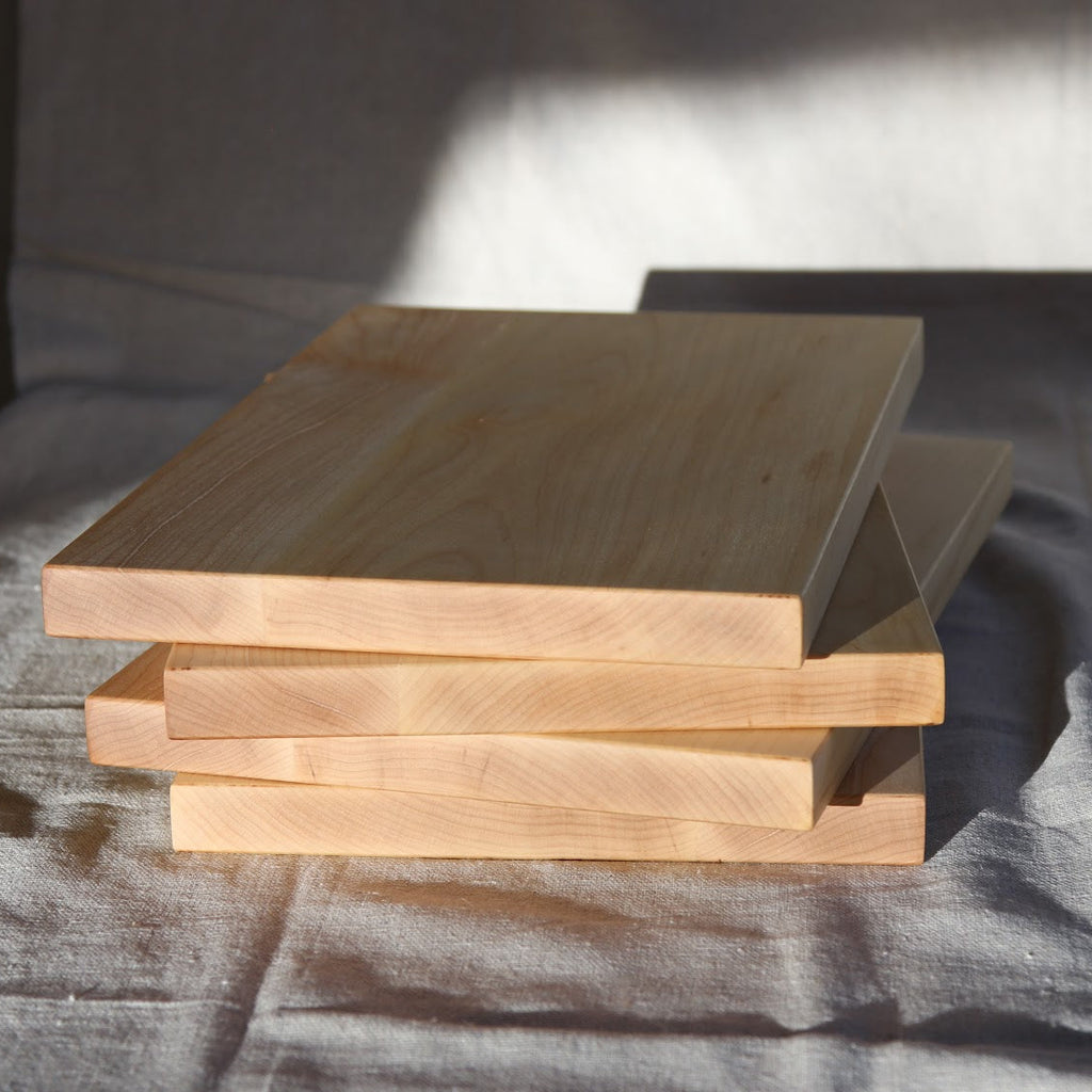 Stack of wooden cutting boards on a textured surface
