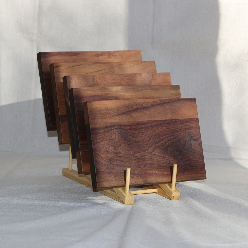 Set of wooden cutting boards on a stand against a white background