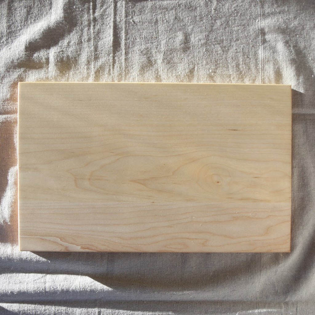 Wooden cutting board on a textured gray surface