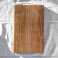 Wooden cutting board on a white cloth background
